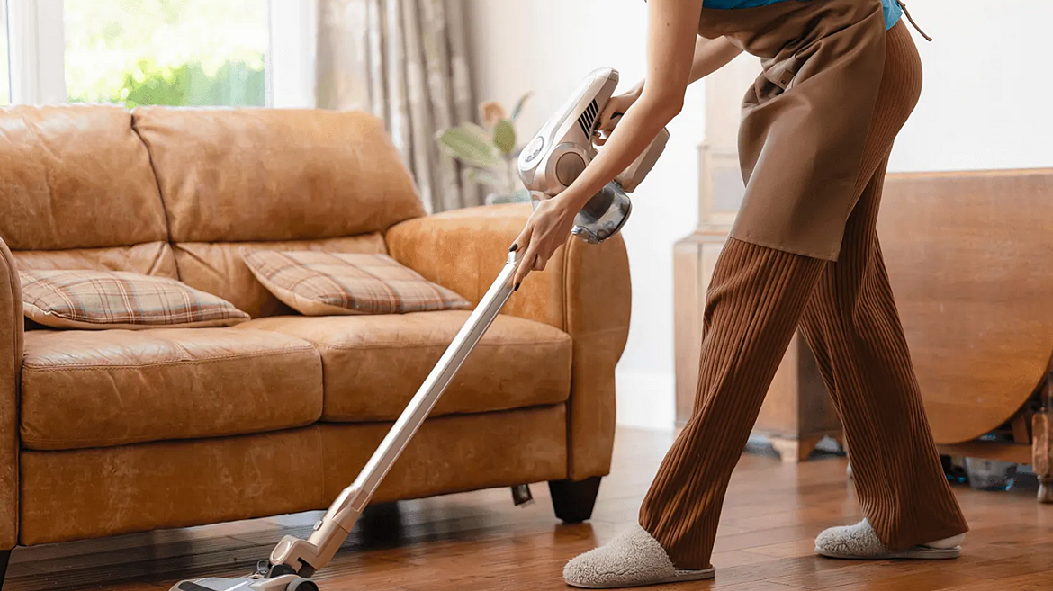 Professional cleaner in gloves wiping down a surface during a home deep cleaning visit
