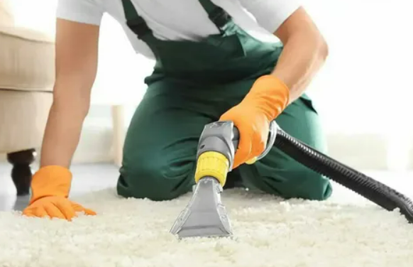 Vacuum cleaner deep cleaning a beige carpet in an empty room
