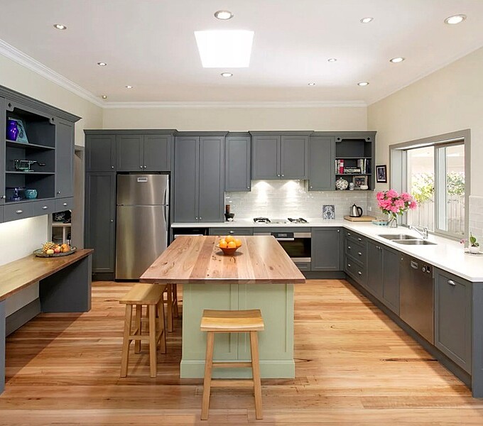 Professional cleaner in gloves wiping down a kitchen surface with a spray bottle and cloth